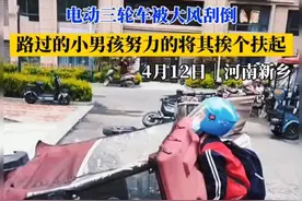 河南：小区门口的电动三轮车被风吹倒，7岁男孩用小小身躯扶起图片