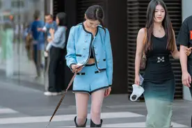 牵着小狗和闺蜜一起逛街的蓝衣时尚姐姐图片