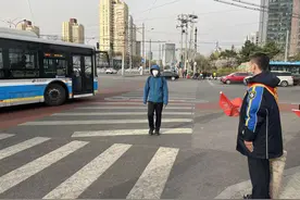 北京公交驾驶员现身路口，举起小旗为了它——图片