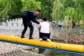 爸爸抱娃挑战独木桥困中间进退两难看得人冒汗，背包男从另一头救下孩子，提醒年轻父母带孩子挑战应量力而行图片