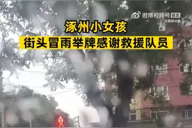 涿州小女孩街头冒雨举牌感谢救援队员，队员：疲惫感一下消失了图片
