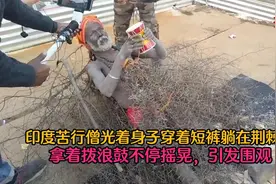 印度苦行僧光着身子整天躺在荆棘上，拿着拨浪鼓摇摆，引发围观图片