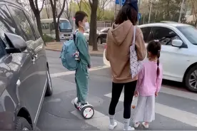 网友偶遇嗯哼，骑平衡车背网球拍变运动小子，一旁大人行为惹争议图片