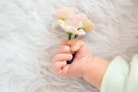 新生儿总是握着小拳头，大多数是正常的，但这个月龄还紧握要警惕图片