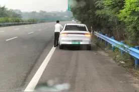 电动汽车电量耗尽，驾驶员高速公路上推车？图片