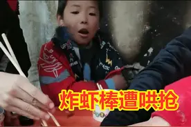 小朋友吃席手抢炸虾棒，一男孩笑看不语，等抢完才不慌不忙夹一个图片