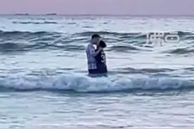 情侣站在海浪里拥吻险些被冲倒，目击者：数百人等待看日出，日出没看到，全看他们了图片