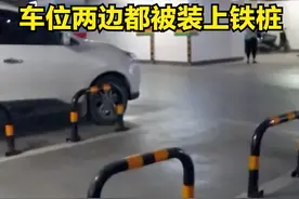 一女子停车位的两边都被邻居安装上铁桩图片