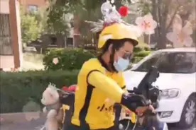 新疆一外卖小哥头戴紫金冠，外卖箱被玩偶环绕图片