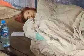缅甸一20岁女子躺在路边，被路人男子掀被子图片