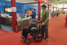 63岁儿子推着90岁母亲逛书市，他说：小时候她给我讲，现在她老了，我多看书给她讲图片