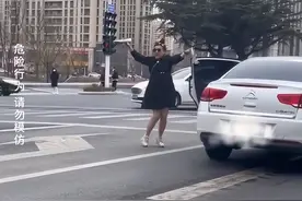 山东一女子在红绿灯处拿着高跟鞋跳舞，还敲货车车门，交警回应：正联系驾驶员，该女子可能有精神问题图片