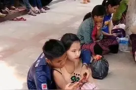 一对情侣光脚坐在地上，男子一心游戏，女子却愿意躺在他怀里图片