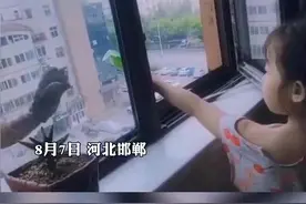 河北邯郸，工人师傅高温天气高空作业，女孩隔窗送雪糕，网友：师傅开心得像一个害羞的小男孩图片