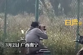 中年男子隔着高校围墙拿望远镜往里面看，目击者：他看的那栋楼是女生公寓，该男子看着五十多岁，是校外人员图片