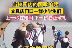 校园内国歌响起，文具店门口小学生自发立正敬礼，网友却说：摆拍图片