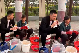 李飞和妈妈开破旧三轮摆地摊卖鱼，蹲路边吃饼，自称这时侯最帅气图片