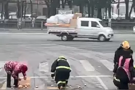 湖北宜昌：暖心！街头车流中消防员帮老奶奶捡橘子图片