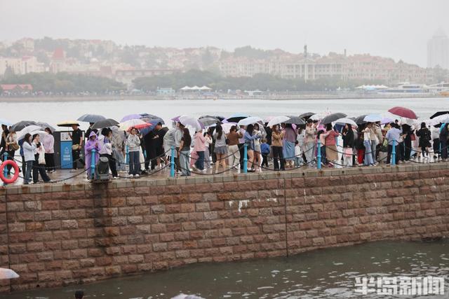 秋雨润栈桥，伞海映人潮