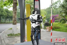 四川“绵阳造”人形机器人上路“实习” 劝导文明交通图片