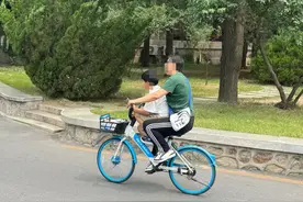 北大校园内，参观游客骑共享单车“花式带娃”，校方回应图片