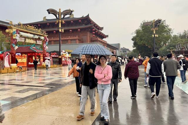 漫步不夜城 雨天游客热情不减