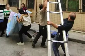 幼童脖子卡防盗窗悬空挂在墙外，有人撑被子有人架梯子，热心工人将她托举回屋内图片