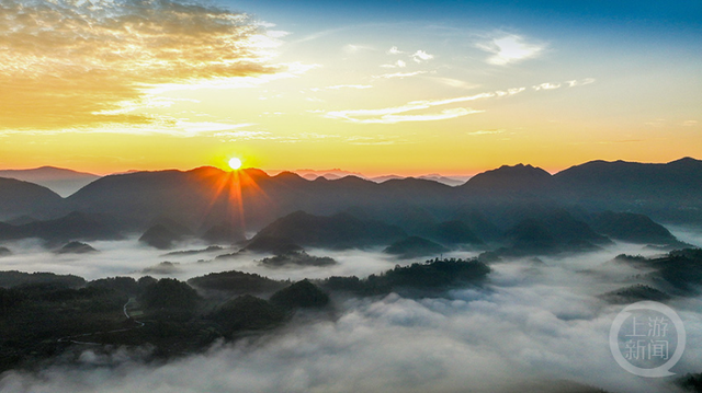 晨雾缭绕间，日出点亮山村
