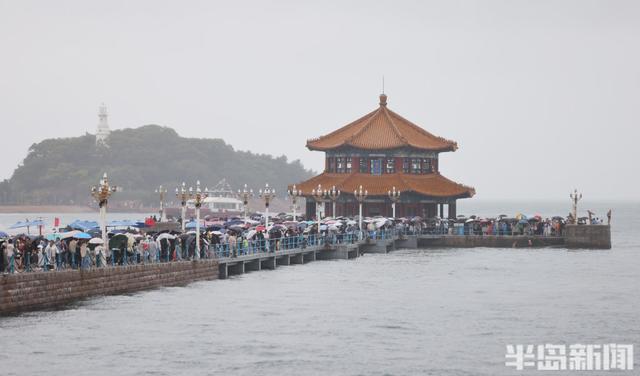 秋雨润栈桥，伞海映人潮