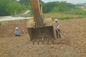 小伙开挖掘机帮老人锄地松土图片