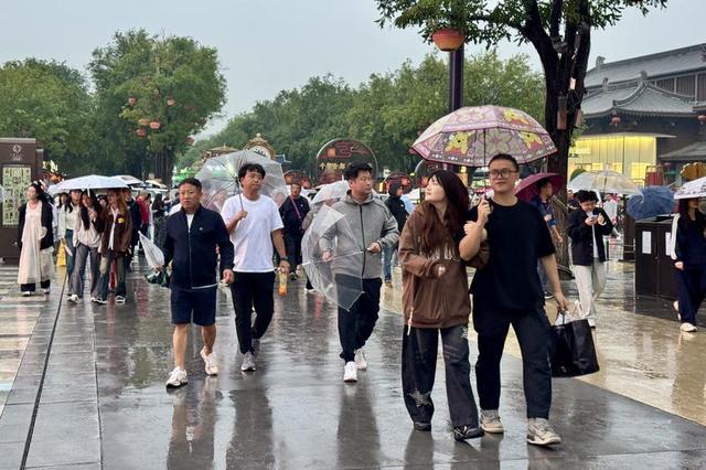 漫步不夜城 雨天游客热情不减