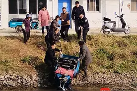 电动三轮车冲下河堤，民辅警路过及时相助图片