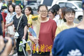 家长手举向日葵送考，寓意“一举夺魁” | 镜相图片