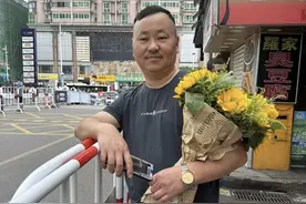 男子抱着妻子自制花束考场外等儿子，“最希望他考完好好休息”图片