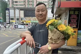 男子抱着妻子自制花束考场外等儿子，“最希望他考完好好休息”图片