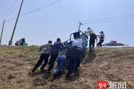 三轮车被大风刮下河堤，警察当“纤夫”拖上来图片