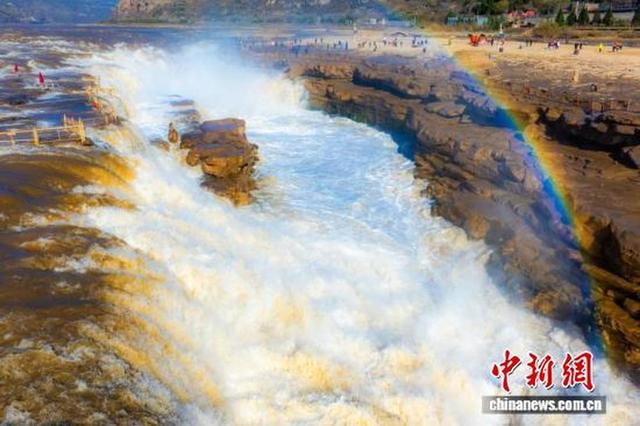 山西壶口展冬日画卷，现“青流飞瀑悬彩练”奇观