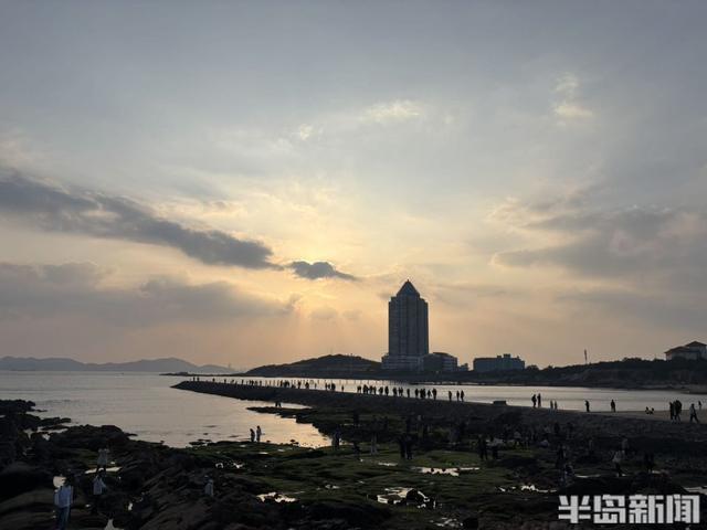 落日穿云洒海面，定格海滨温柔