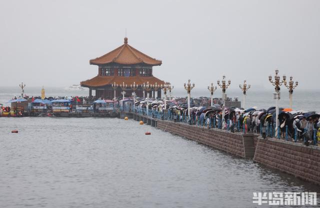 秋雨润栈桥，伞海映人潮