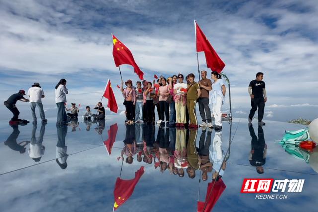 大美红图丨最爱中国红 游客在天空之镜舞动国旗
