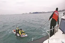 两男子撑着皮划艇海上漂，巡逻艇赶到将他们救回图片