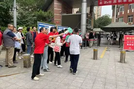 高考北京十八中考点：教师送考仪式感拉满，志愿者为家长送雨衣图片