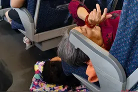 动车上，为让85岁母亲在座位上睡得更舒服，女儿躺地板休息！当事人回应图片