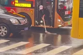 拍客｜大雨堵车公交无法行进，司机站车门口就着积水洗拖把 目击者：松弛感十足图片