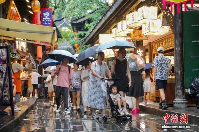成都：暑期游客雨中游览锦里古街