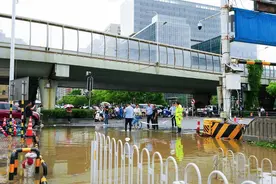 暴雨中的武汉大学珞珈门：家长互助趟渍水，城管拉绳筑 “安全线”图片