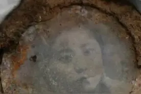 迁葬烈士遗骸时发现其怀中遗物，烈士双手“紧握”一面镶着照片的镜子，“猜测照片中是他未婚妻，82年了，照片还清晰可见”图片