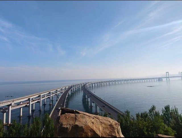 大连一跨海大桥观景台有游客翻栏杆踩空心造景石拍照，当地回应：很难完全阻止