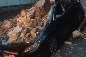 临街的一段院墙在暴雨中突然坍塌，一辆小车被砸受损图片