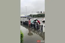 襄阳暴雨突袭，汽车路面“趴窝”，汽修小哥蹚水救援图片